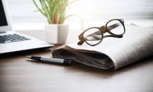 Newspaper,With,Computer,On,Table