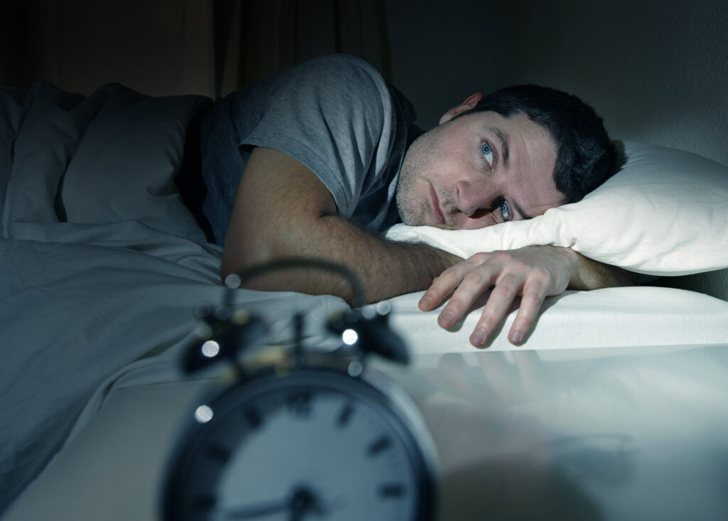 Young,Man,In,Bed,With,Eyes,Opened,Suffering,Insomnia,And